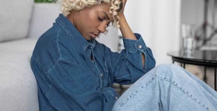 devastated depressed young woman sits with her head her hands mental health issues concept