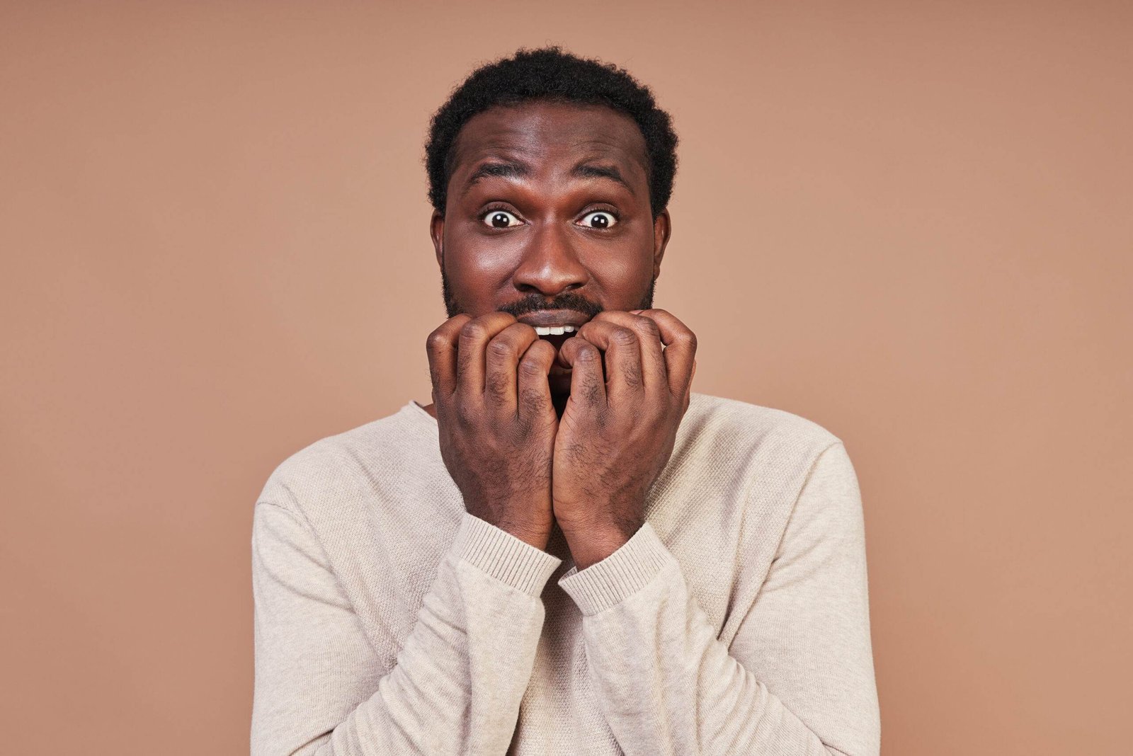 scared young african man casual clothing making face looking camera scaled